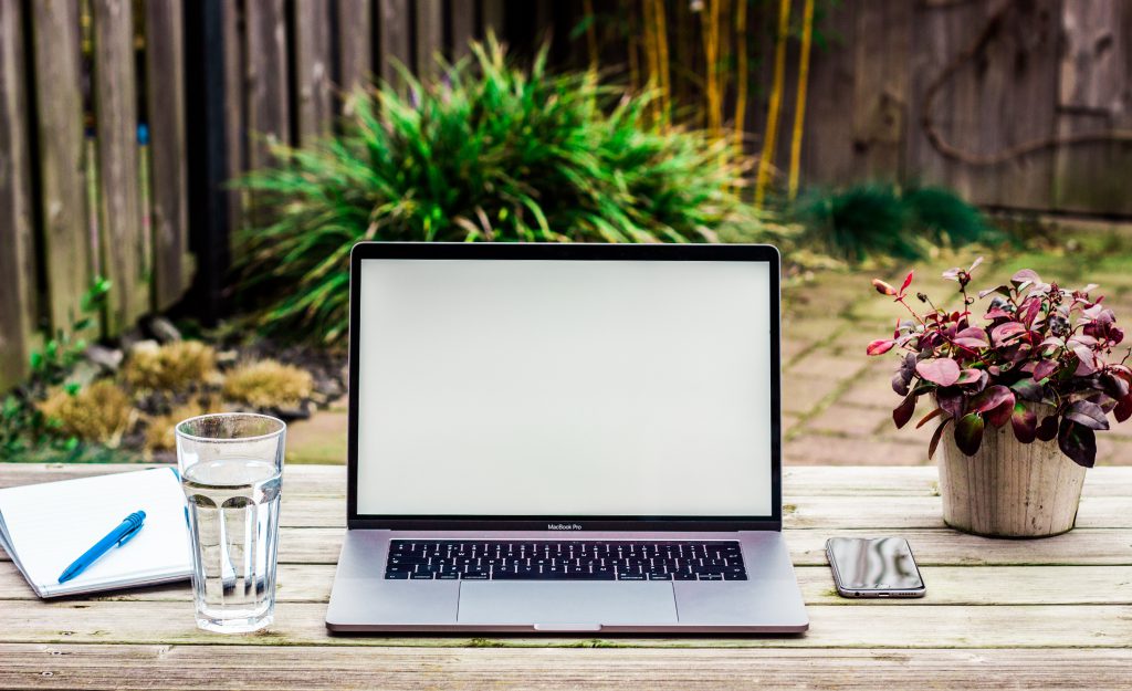 A digital nomad's laptop on a table outdoors.